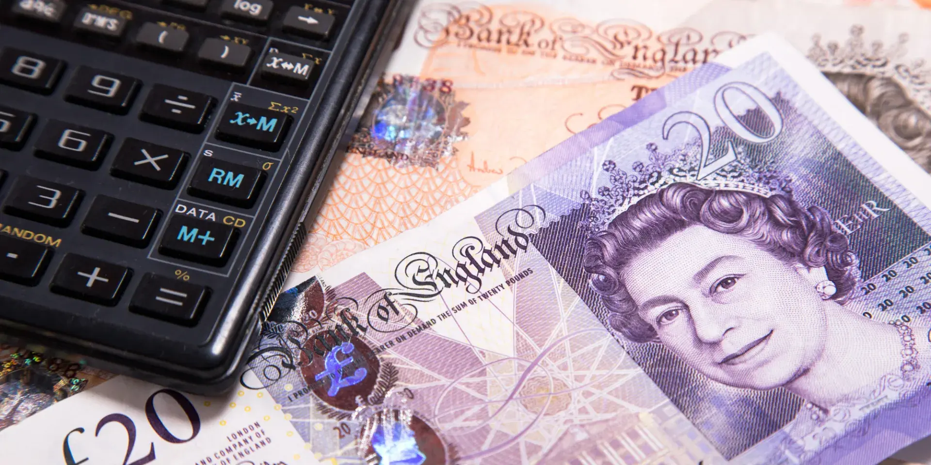Calculator lying on top of £10 and £20 notes