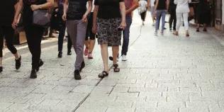 People walking down street, pictured from torso down