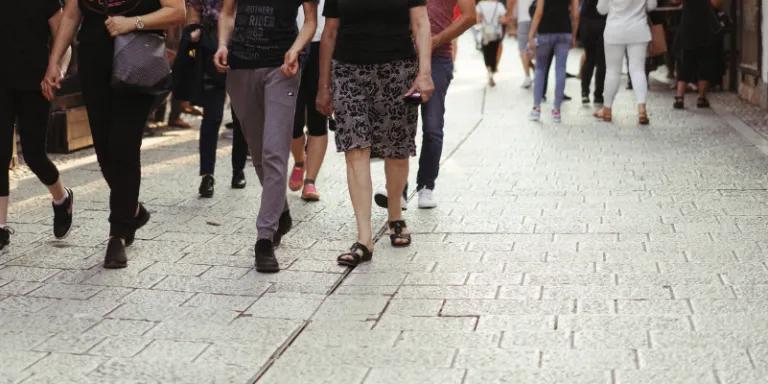 People walking down street, pictured from torso down