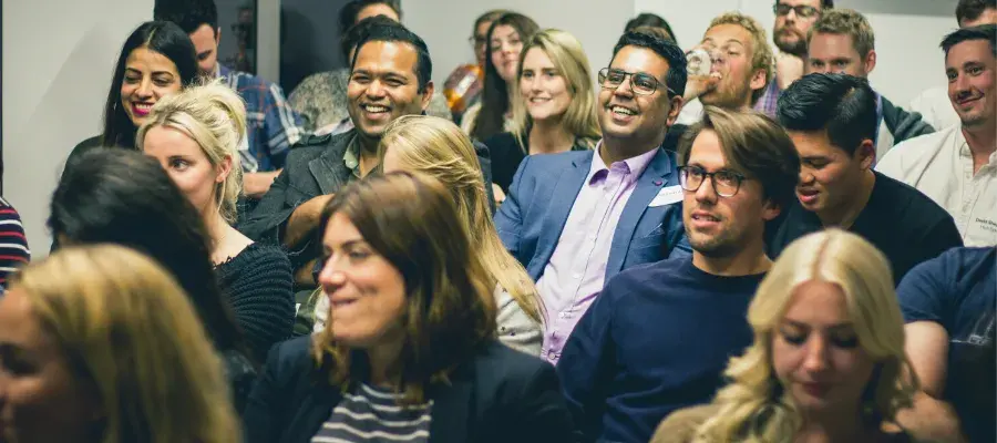 Smiling audience pictured seated at event