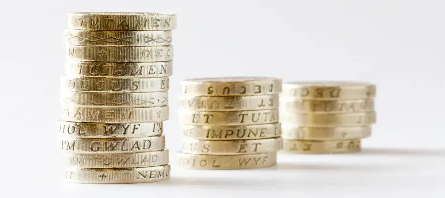 Three stacks of pound coins against white background