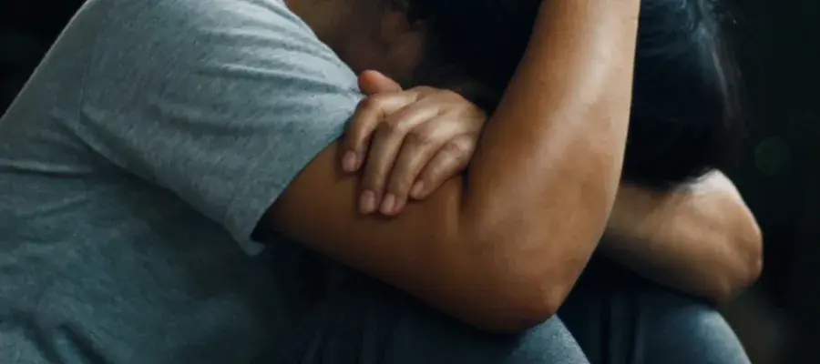 Person sitting with head in their hands