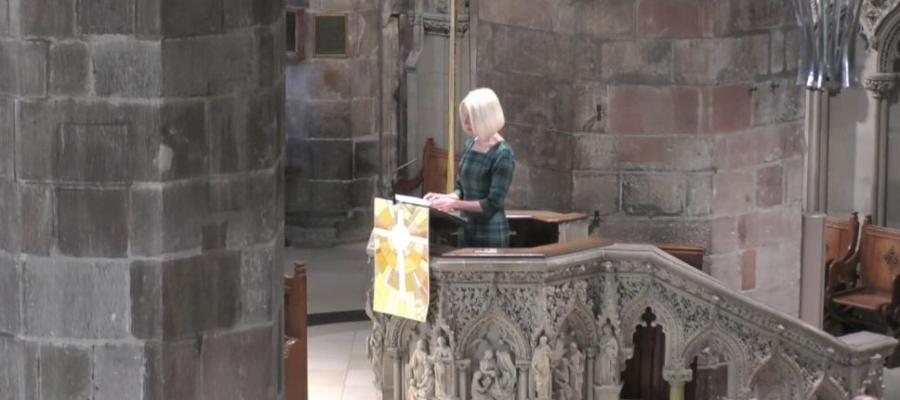 A woman standing in the pulpit of St Giles Church in Edinburgh, reading from her speech.