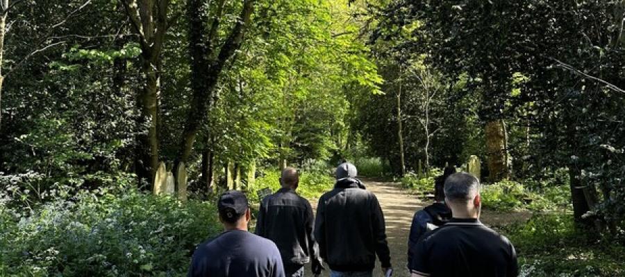 A group of people walking together on a path in a forest.