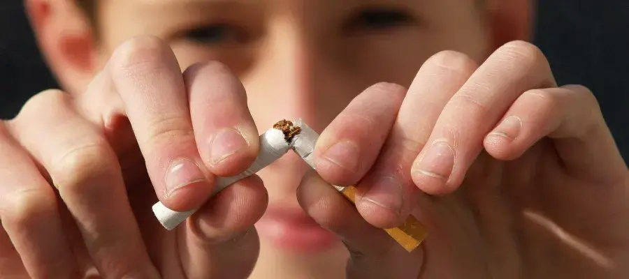 Image of a man snapping cigarette in half
