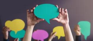 Hands holding coloured speech bubbles