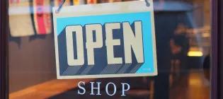 A glass shop front with an open sign in the window.