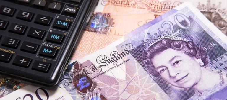 Calculator lying on top of £10 and £20 notes